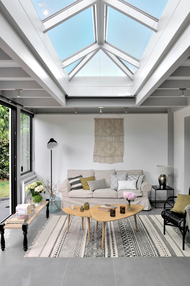 Immagine di un soggiorno tradizionale aperto con pareti bianche e pavimento grigio