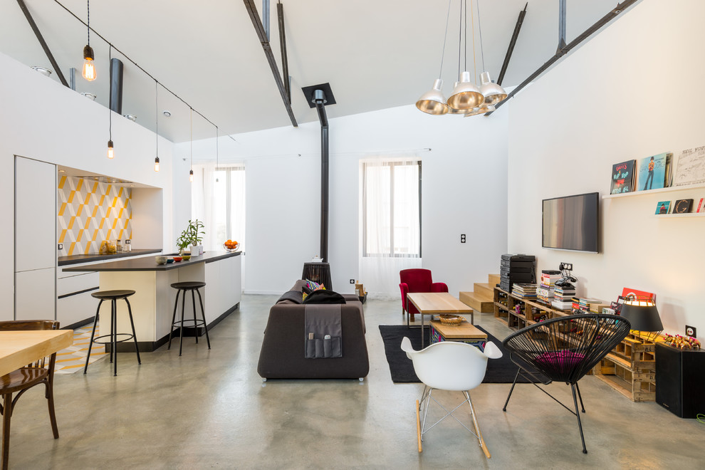 Foto di un grande soggiorno design aperto con pareti bianche, pavimento in cemento e TV a parete
