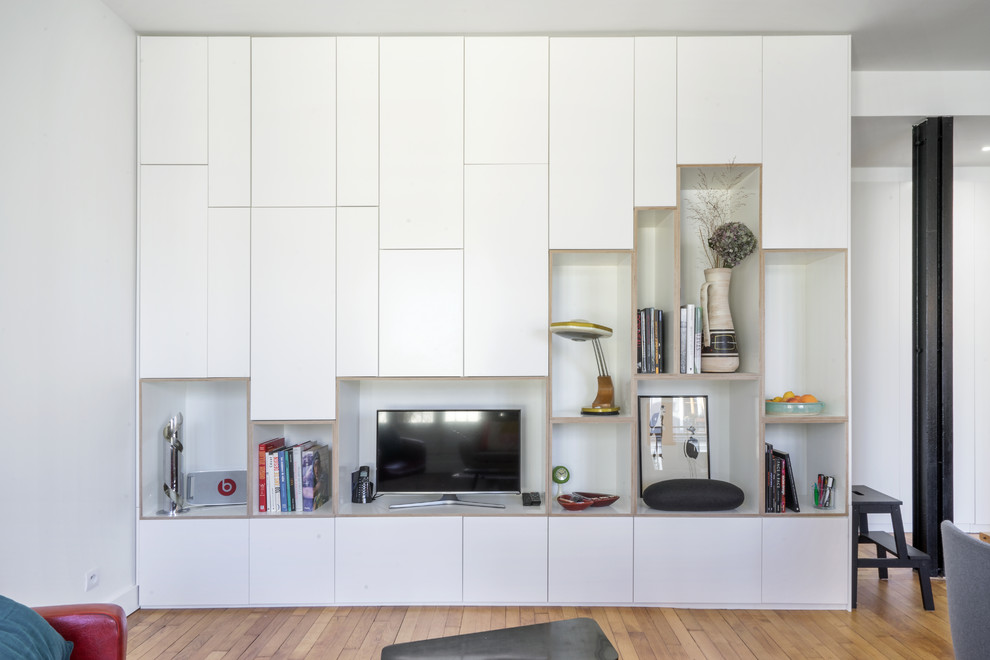 Идея дизайна: гостиная комната с с книжными шкафами и полками, белыми стенами, светлым паркетным полом и отдельно стоящим телевизором