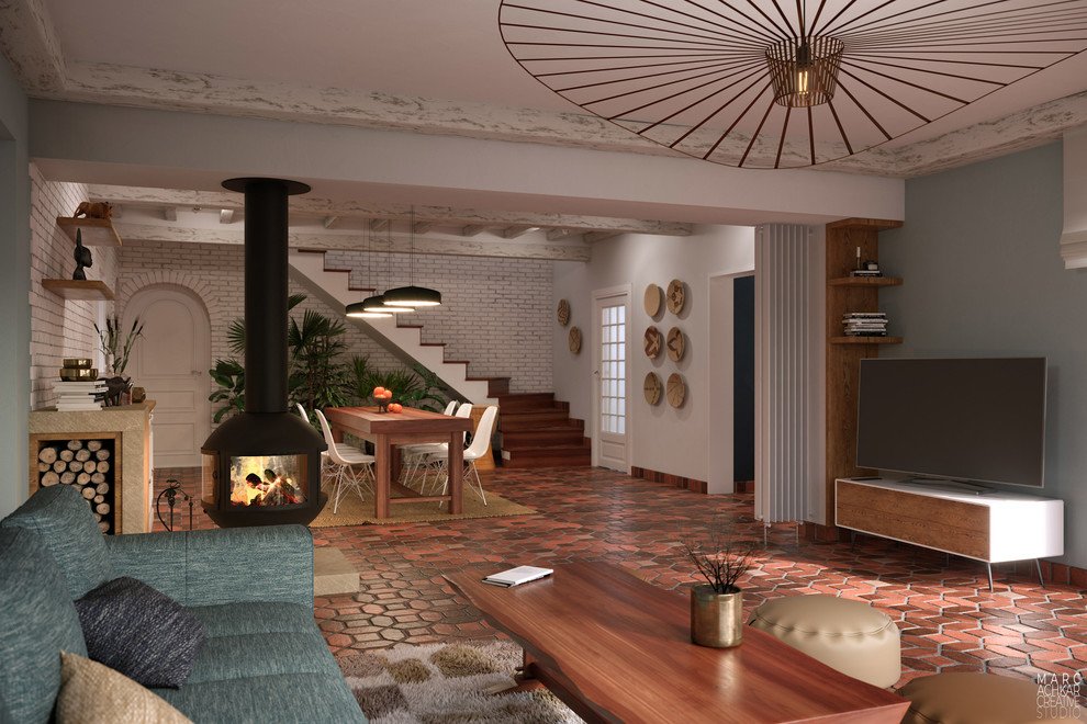 Стильный дизайн: открытая гостиная комната среднего размера в стиле кантри с полом из терракотовой плитки, подвесным камином, отдельно стоящим телевизором, красным полом и синими стенами - последний тренд