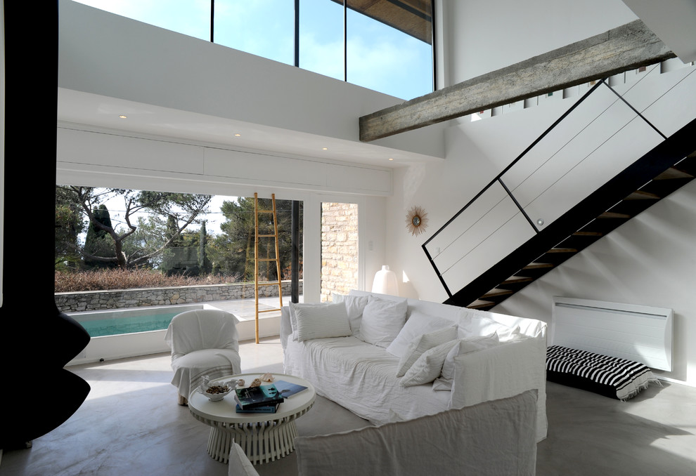 На фото: гостиная комната среднего размера в современном стиле с белыми стенами и бетонным полом с