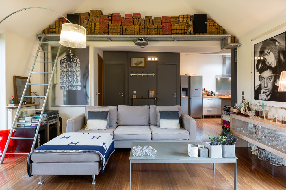 Aménagement d'une grande salle de séjour contemporaine ouverte avec un bar de salon, un mur blanc et un sol en bois brun.