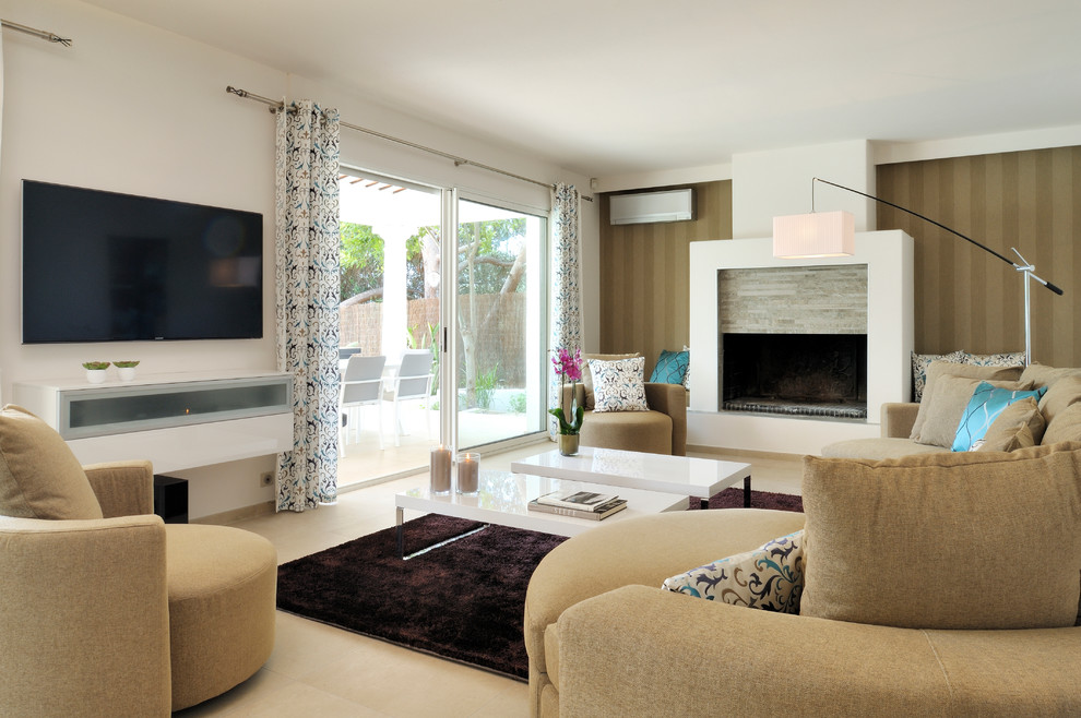 Cette image montre une salle de séjour design avec un mur blanc, une cheminée standard, un manteau de cheminée en pierre, un téléviseur fixé au mur et un sol beige.
