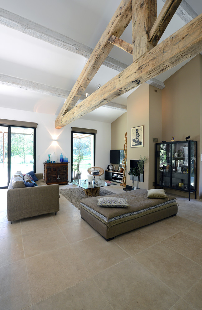 Immagine di un soggiorno bohémian di medie dimensioni e aperto con pareti beige, pavimento con piastrelle in ceramica e TV a parete
