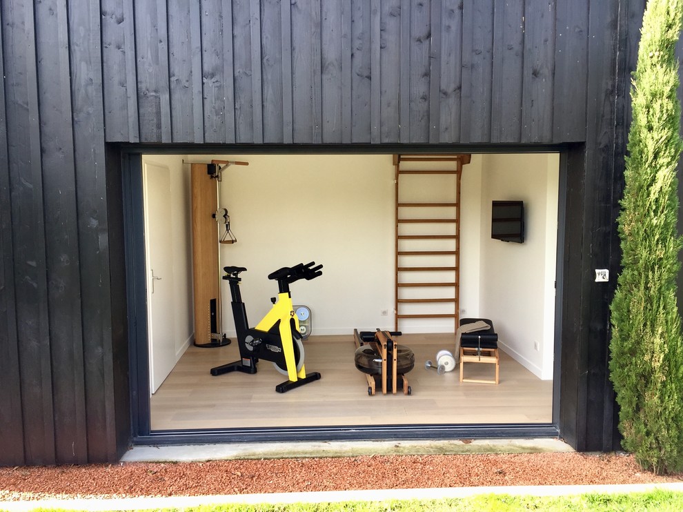 Photo of a small scandinavian multi-use home gym in Bordeaux with white walls, laminate floors and beige floors.