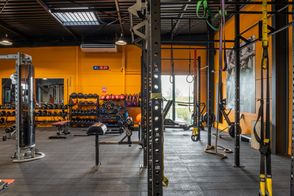 Multifunktionaler, Großer Industrial Fitnessraum mit oranger Wandfarbe in Rennes