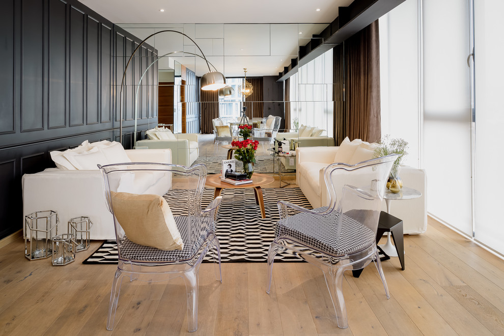 Esempio di un soggiorno design con pareti nere, pavimento in legno massello medio e pavimento marrone