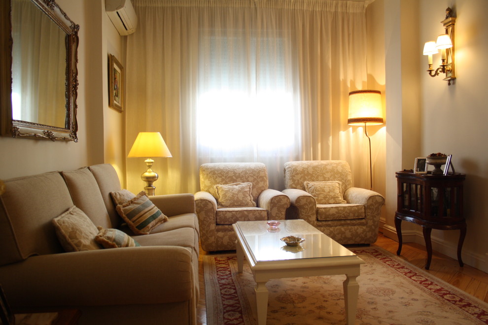 Foto di un soggiorno chic di medie dimensioni e chiuso con sala formale, pareti beige, pavimento in legno massello medio e nessun camino