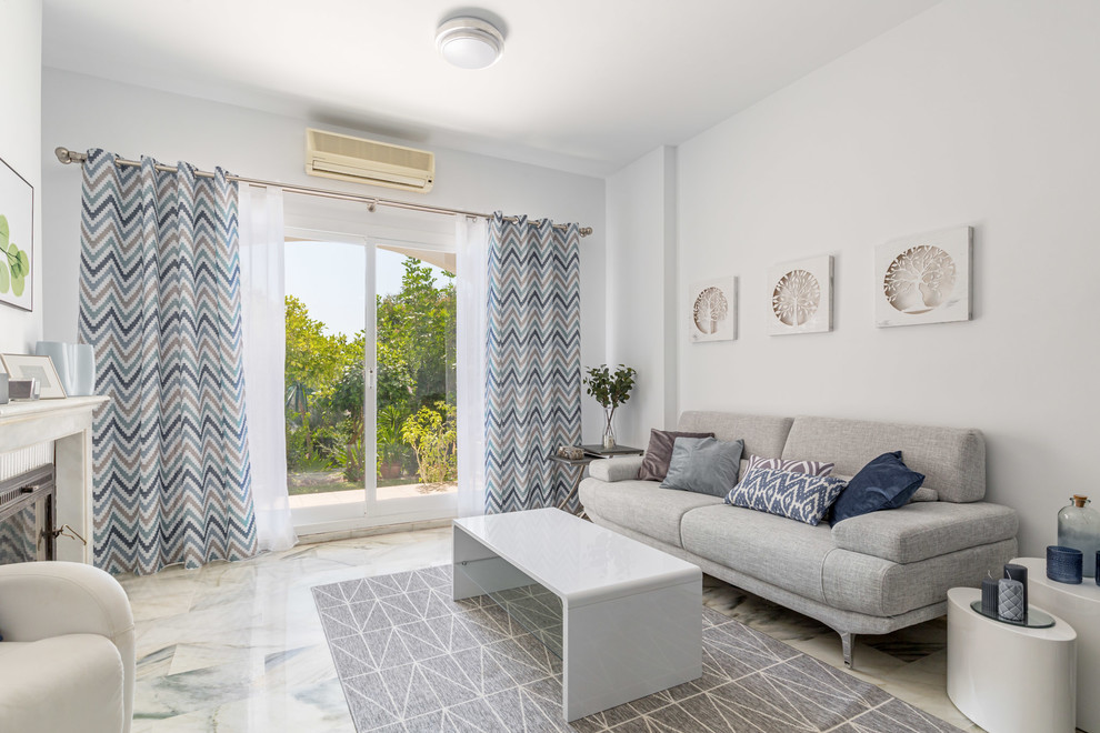 Kleines, Offenes Modernes Wohnzimmer mit weißer Wandfarbe, Marmorboden, Kamin, Kaminumrandung aus Stein und grauem Boden in Malaga