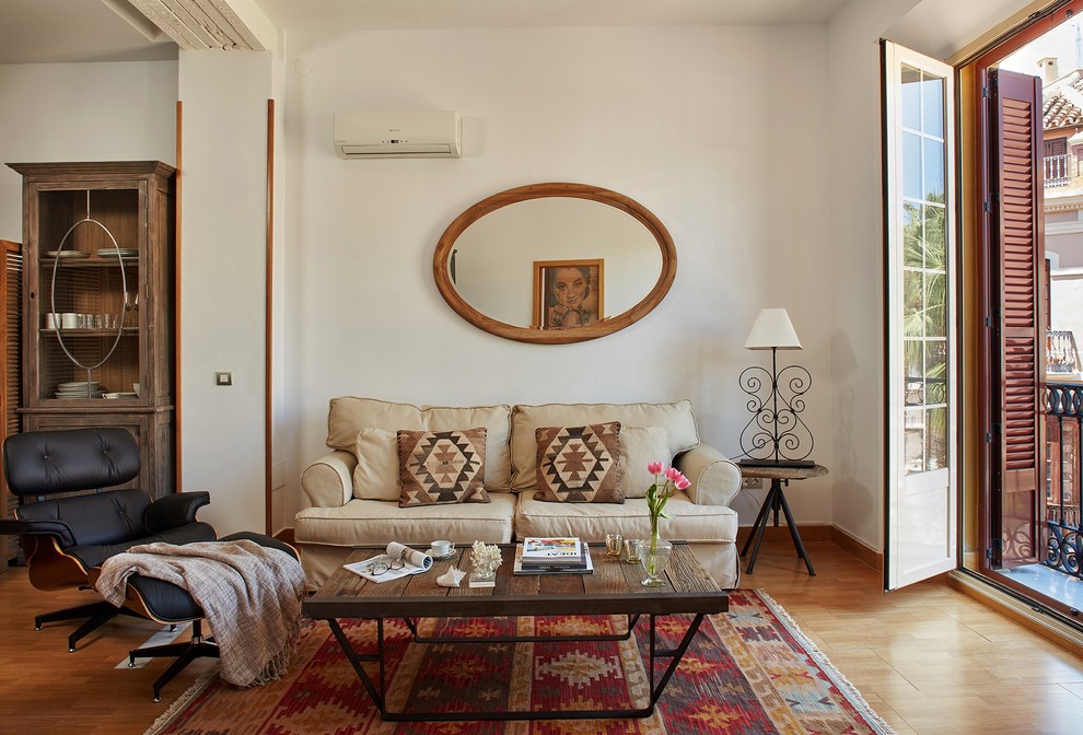 Ejemplo de salón para visitas abierto tradicional de tamaño medio sin chimenea con paredes blancas, suelo de madera en tonos medios y pared multimedia