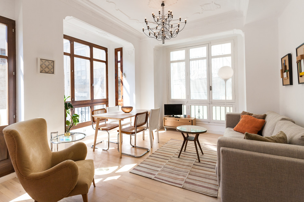 Foto de salón tradicional renovado con paredes blancas, suelo de madera clara, televisor independiente y suelo beige