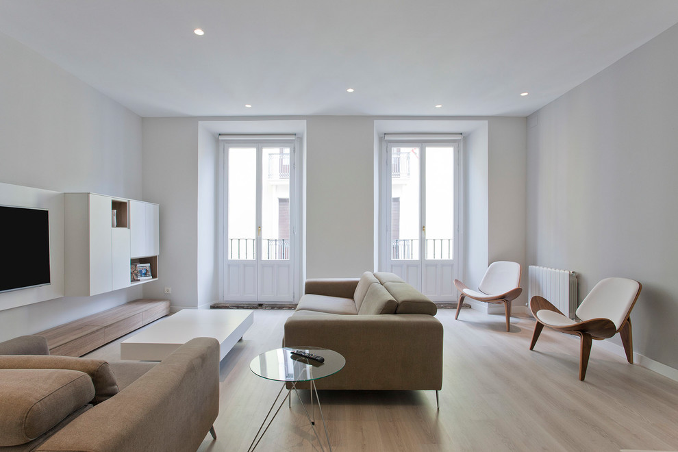 Modelo de salón abierto, minimalista, de tamaño medio, con suelo de madera clara