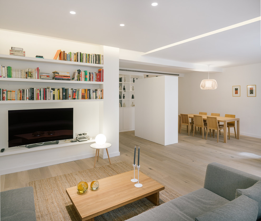 Cette photo montre un salon scandinave de taille moyenne et ouvert avec un mur blanc, parquet clair, une bibliothèque ou un coin lecture et un téléviseur indépendant.