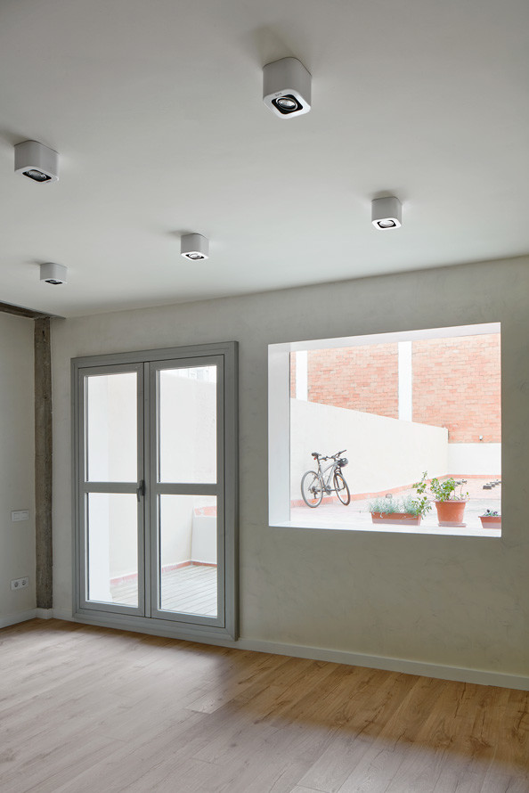 Ejemplo de salón abierto minimalista de tamaño medio con paredes blancas y suelo de madera en tonos medios