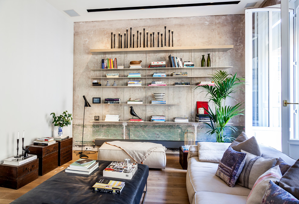 Modelo de biblioteca en casa abierta contemporánea de tamaño medio sin chimenea y televisor con suelo de madera en tonos medios y paredes beige