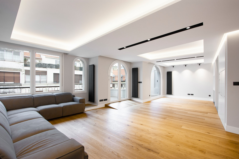 Modelo de salón contemporáneo con paredes grises y suelo de madera en tonos medios