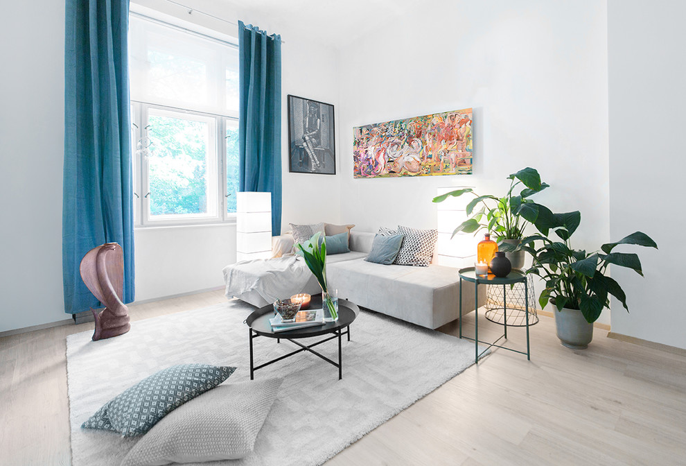 Источник вдохновения для домашнего уюта: двухуровневая гостиная комната среднего размера в современном стиле с белыми стенами, полом из ламината, телевизором на стене и серым полом