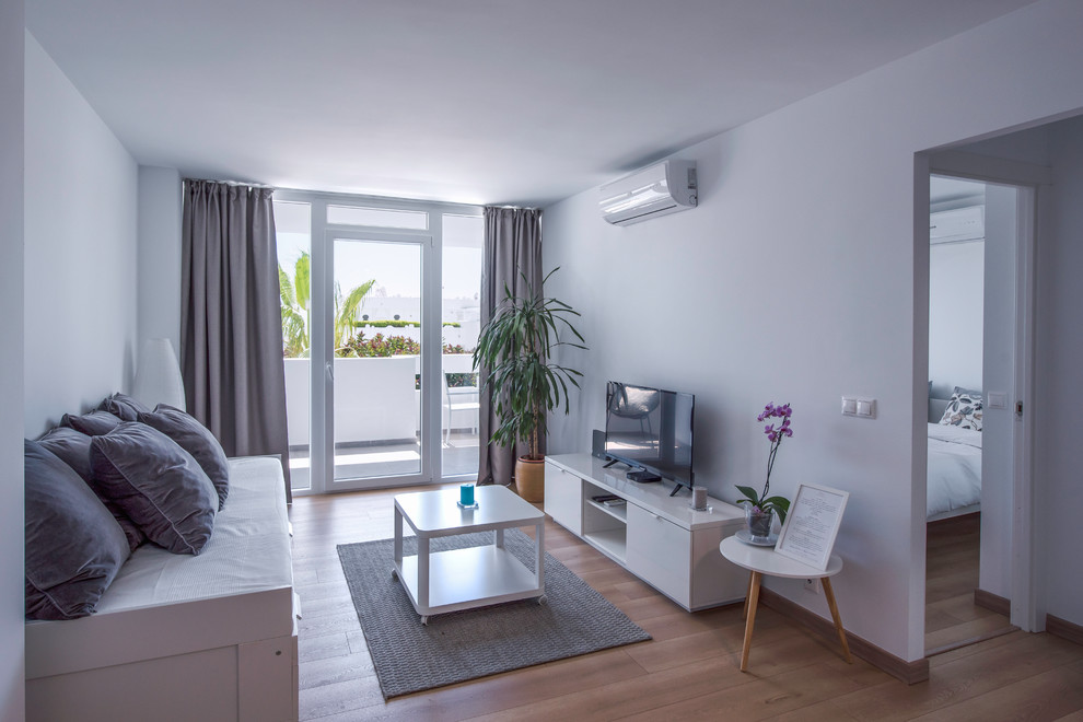 Immagine di un soggiorno costiero con sala formale, pareti bianche, pavimento in legno massello medio, TV autoportante e pavimento beige