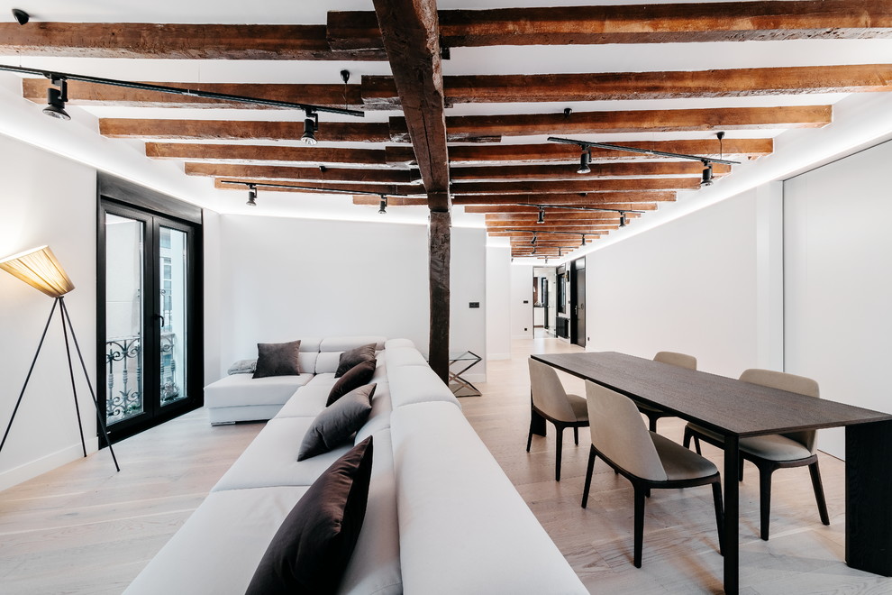 Ejemplo de salón abierto contemporáneo con paredes blancas, suelo de madera clara y suelo beige