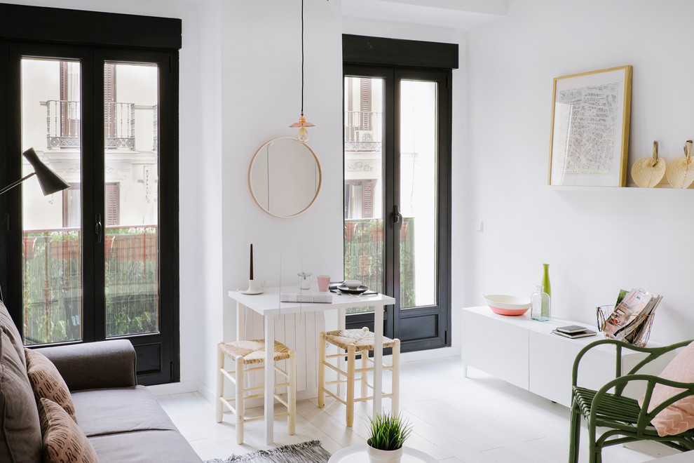 This is an example of a small scandinavian formal open plan living room in Madrid with white walls, painted wood flooring, no fireplace and no tv.