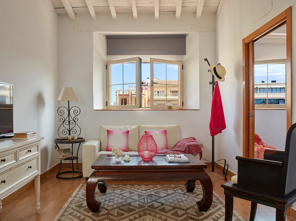 Foto de salón para visitas cerrado mediterráneo pequeño sin chimenea con paredes blancas, televisor independiente y suelo de madera en tonos medios