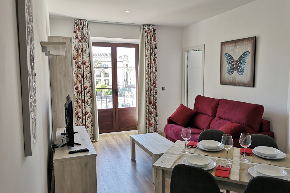 Kleines, Offenes Stilmix Wohnzimmer mit beiger Wandfarbe, Laminat und braunem Boden in Sonstige