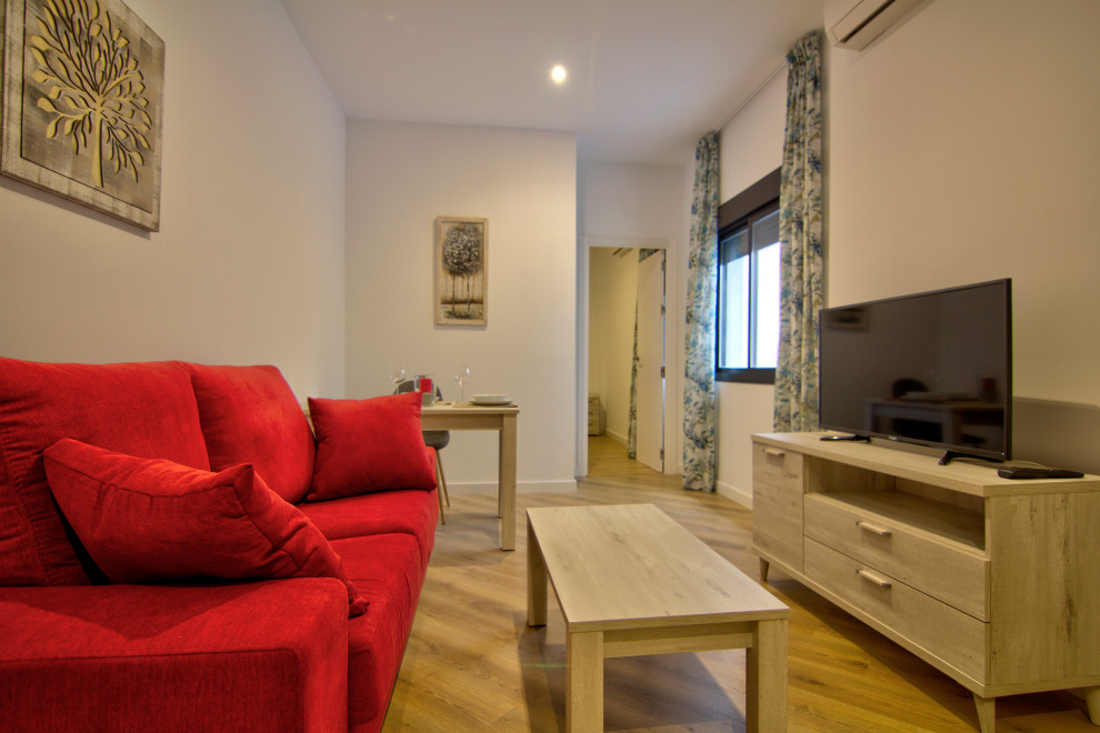 Immagine di un piccolo soggiorno eclettico aperto con pareti beige, pavimento in laminato e pavimento marrone