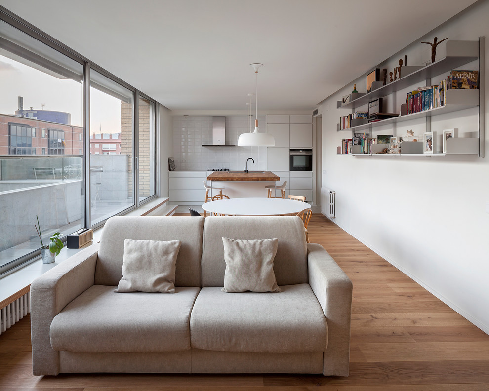 Ejemplo de salón para visitas abierto minimalista de tamaño medio sin televisor con suelo de madera en tonos medios y paredes blancas