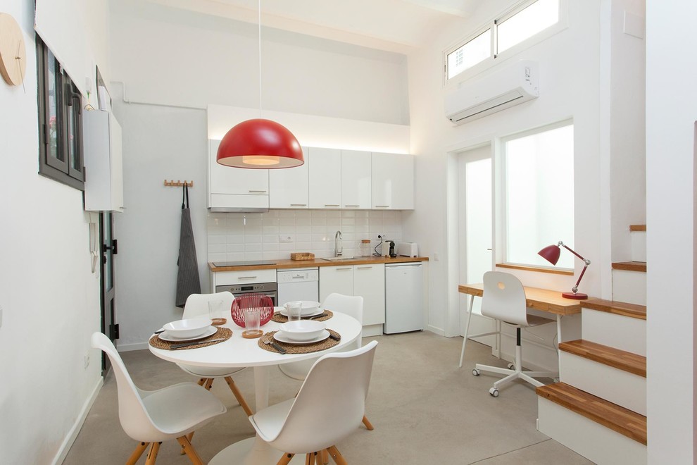 Cette image montre un petit salon méditerranéen avec un mur blanc, sol en béton ciré et un sol gris.