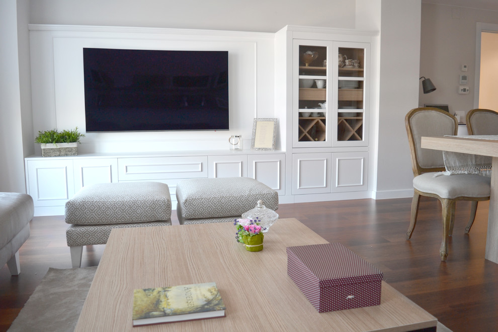 Immagine di un soggiorno tradizionale di medie dimensioni e chiuso con pareti bianche, pavimento in legno massello medio, TV a parete e pavimento marrone