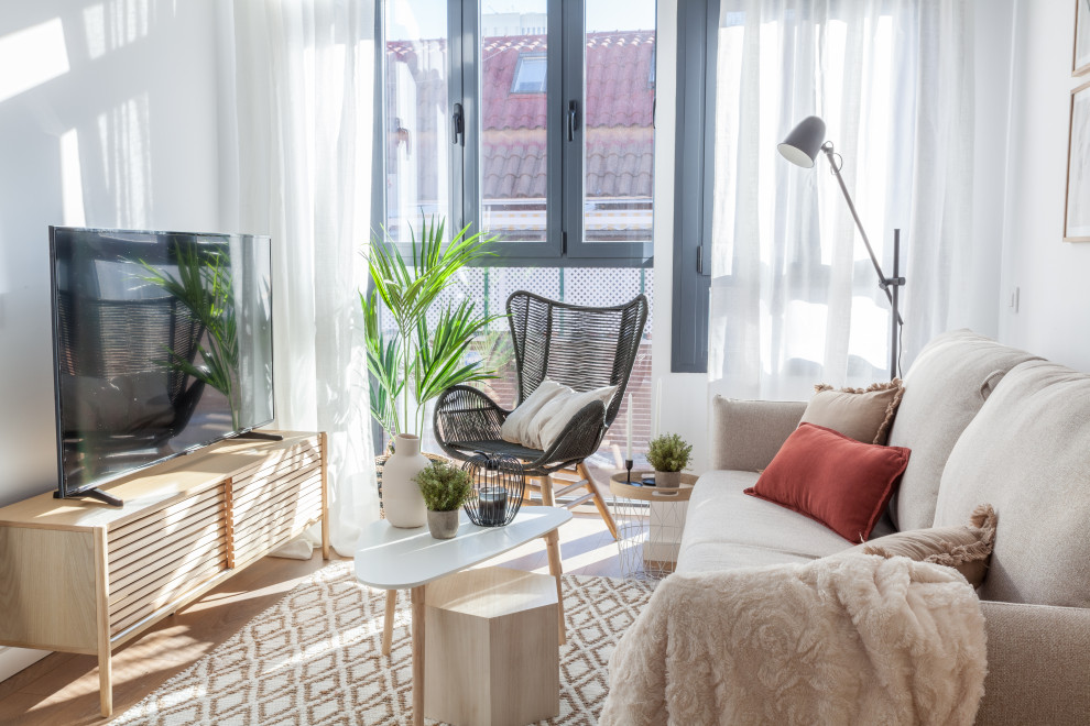 Small scandi open plan living room in Madrid with white walls, dark hardwood flooring, a freestanding tv and brown floors.