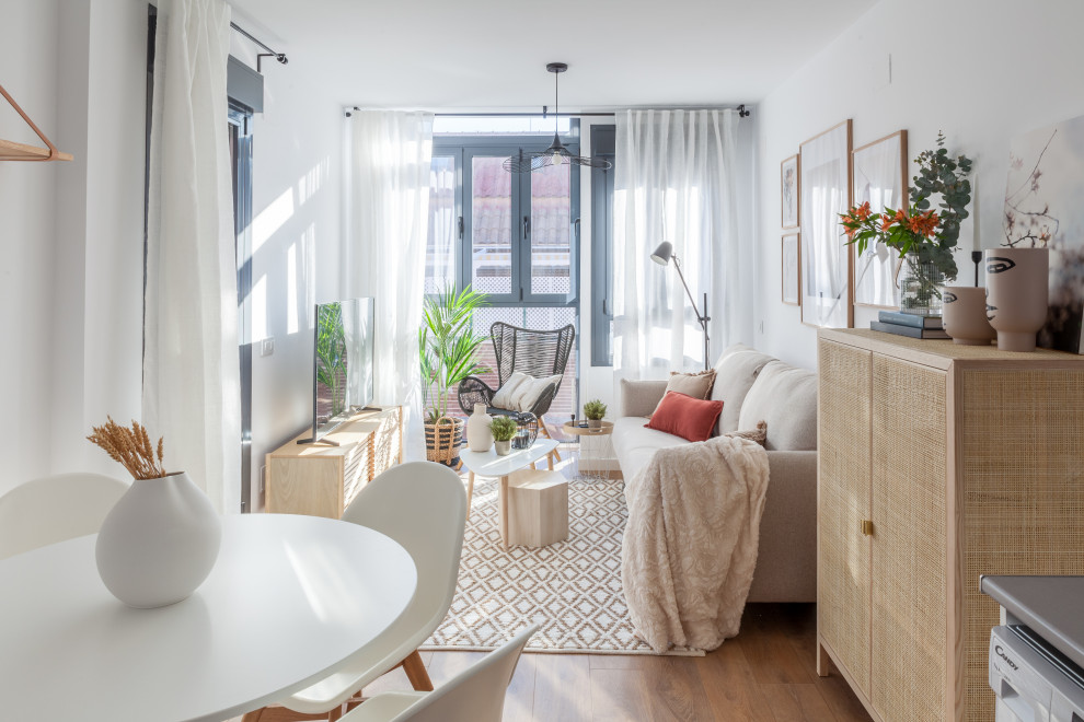 Kleines, Offenes Skandinavisches Wohnzimmer mit weißer Wandfarbe, dunklem Holzboden, freistehendem TV und braunem Boden in Madrid