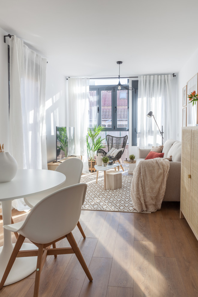 Cette image montre un petit salon nordique ouvert avec un mur blanc, parquet foncé, un téléviseur indépendant et un sol marron.