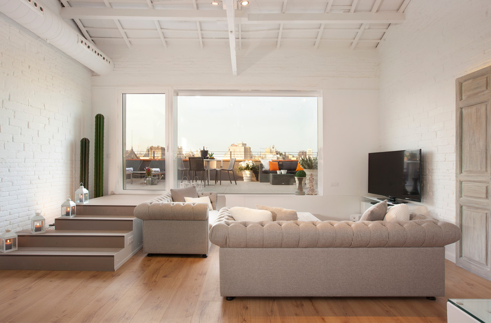 Großes, Repräsentatives, Offenes Industrial Wohnzimmer ohne Kamin mit weißer Wandfarbe, braunem Holzboden und Multimediawand in Barcelona