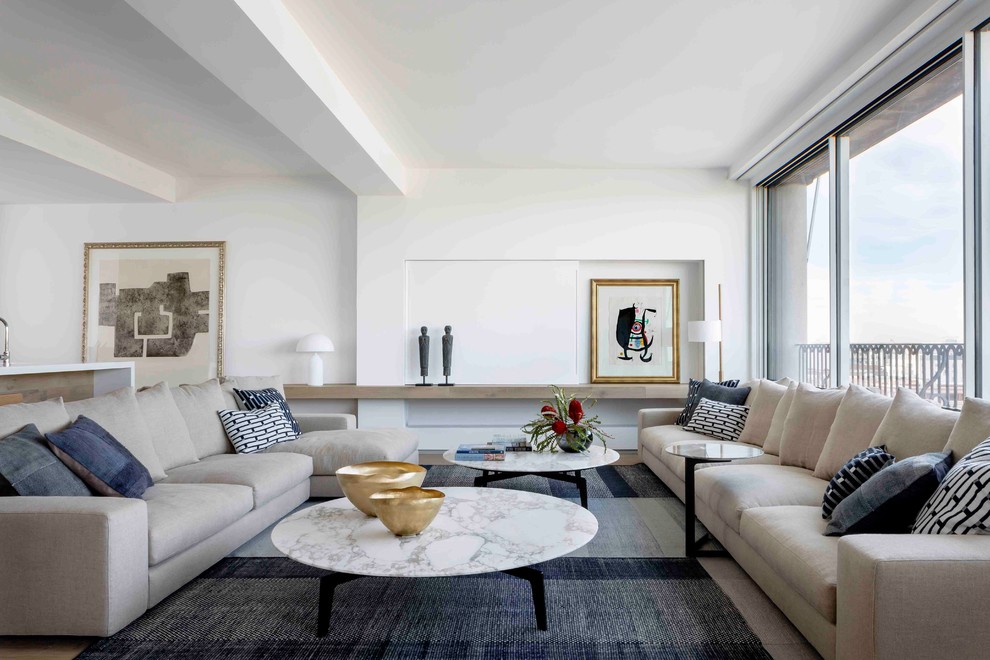Réalisation d'un salon design ouvert avec une salle de réception, un mur blanc, parquet clair et un sol beige.
