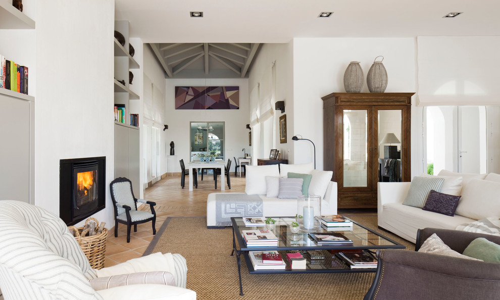 Esempio di un grande soggiorno minimal aperto con sala formale, pareti bianche, pavimento in terracotta, stufa a legna e nessuna TV