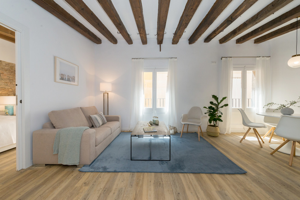 Foto de salón abierto mediterráneo con paredes blancas, suelo de madera en tonos medios y suelo marrón