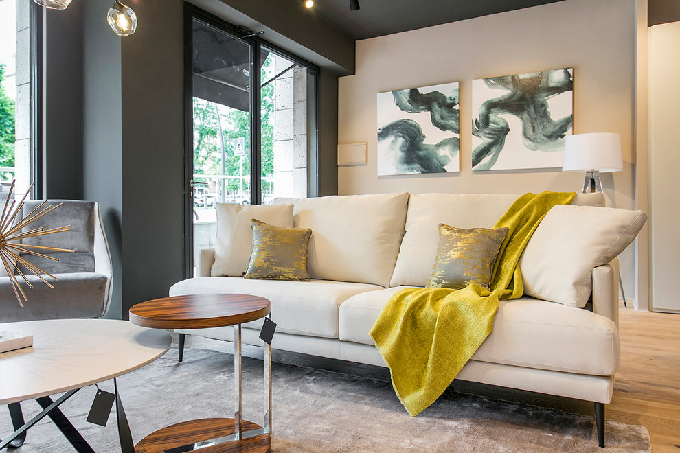 Inspiration pour un petit salon minimaliste ouvert avec un bar de salon, un mur noir, parquet clair, un téléviseur fixé au mur et un sol beige.