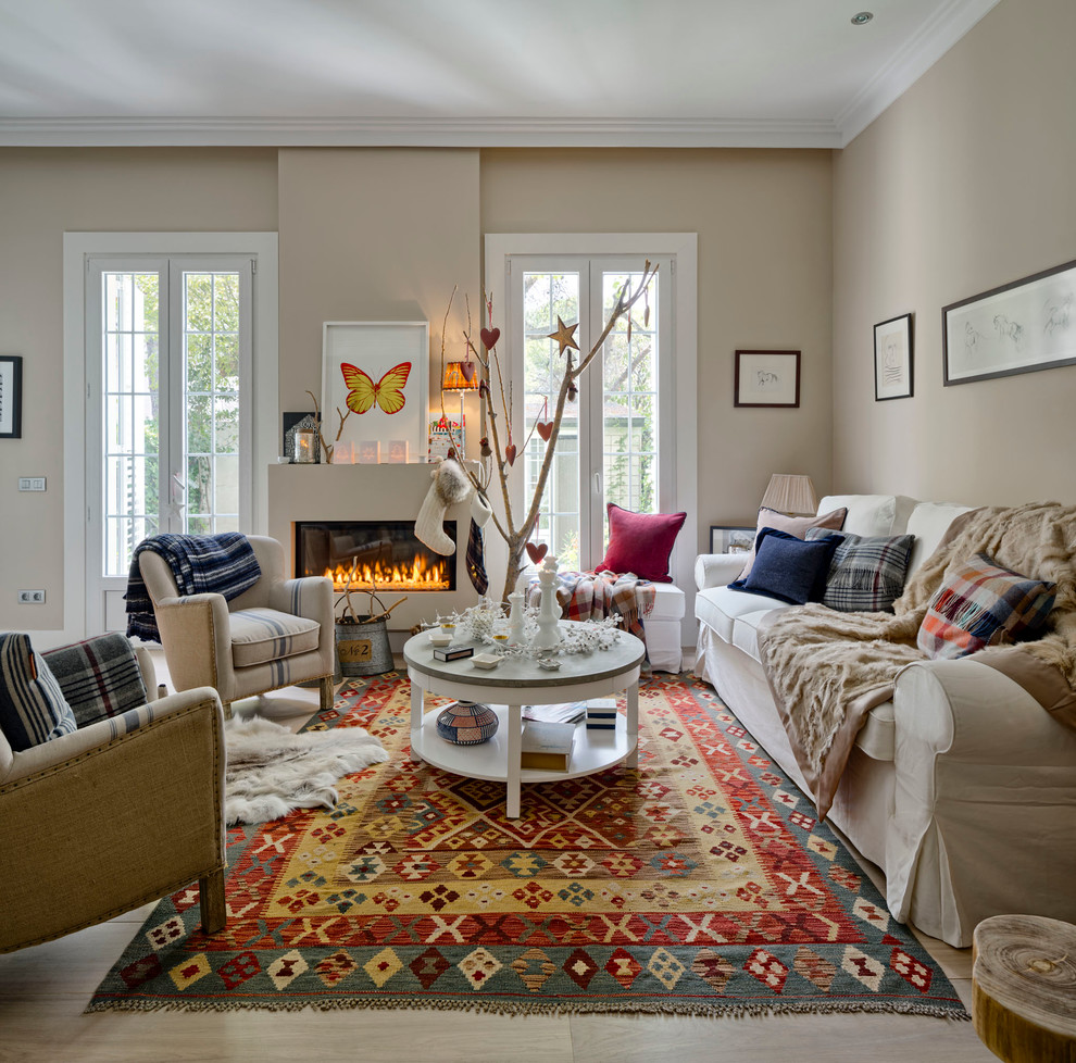 Foto de salón para visitas cerrado escandinavo grande sin televisor con paredes beige, suelo de madera clara, todas las chimeneas y marco de chimenea de yeso