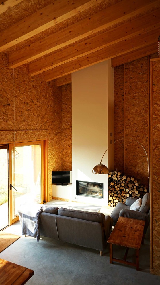 Стильный дизайн: маленькая открытая гостиная комната в стиле лофт с бетонным полом, горизонтальным камином и фасадом камина из штукатурки для на участке и в саду - последний тренд