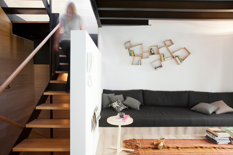 Diseño de salón abierto contemporáneo grande con paredes blancas, suelo de madera en tonos medios, televisor colgado en la pared y suelo marrón