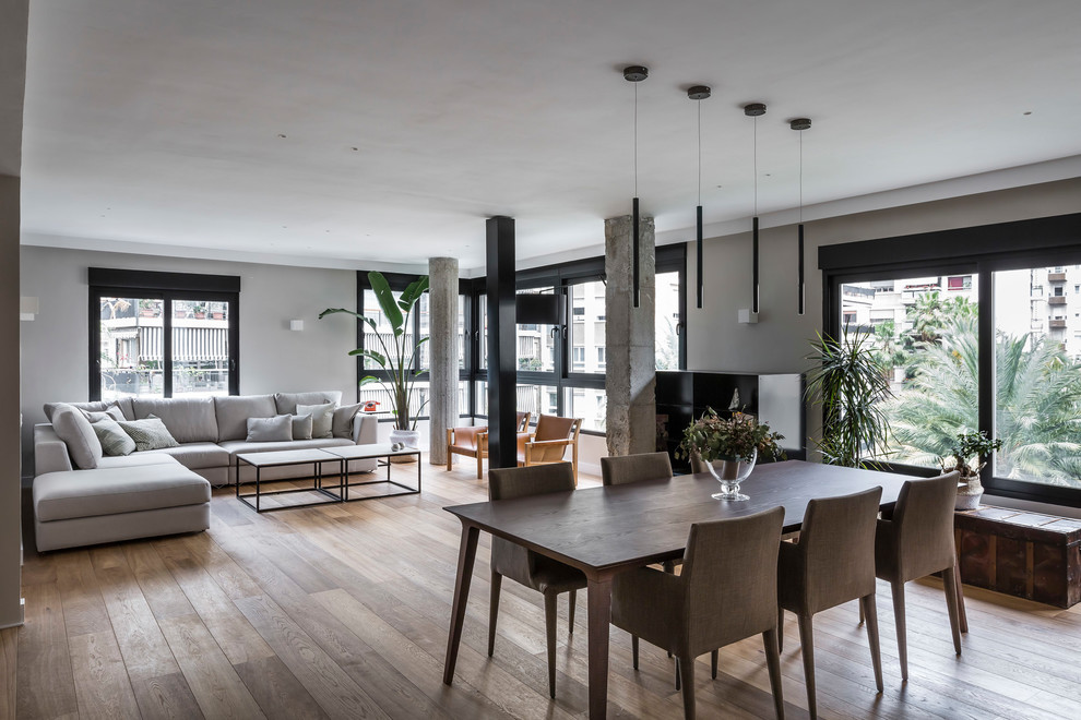 Idee per un grande soggiorno minimal con pavimento in legno massello medio e pavimento marrone