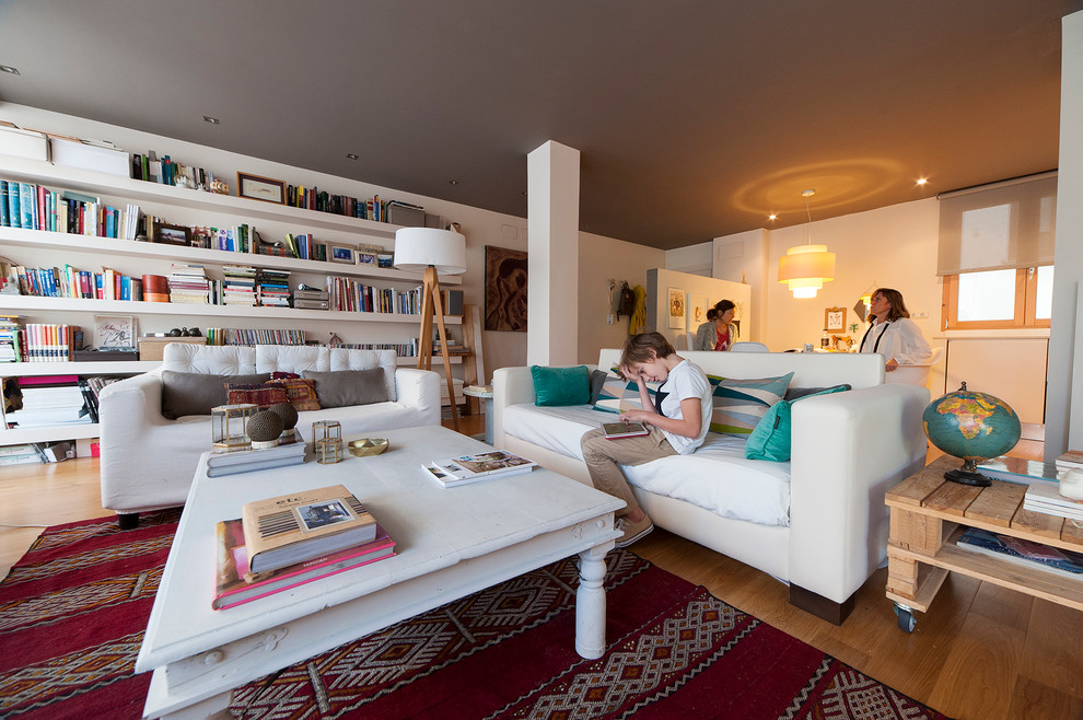 Imagen de biblioteca en casa abierta escandinava grande con paredes blancas y suelo de madera en tonos medios