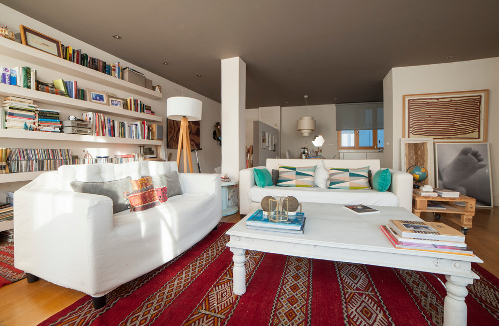 Diseño de biblioteca en casa abierta nórdica grande sin chimenea y televisor con paredes blancas y suelo de madera en tonos medios