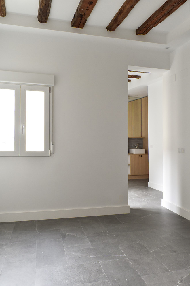 Esempio di un soggiorno minimal aperto e di medie dimensioni con pareti bianche, pavimento con piastrelle in ceramica, nessun camino e pavimento grigio