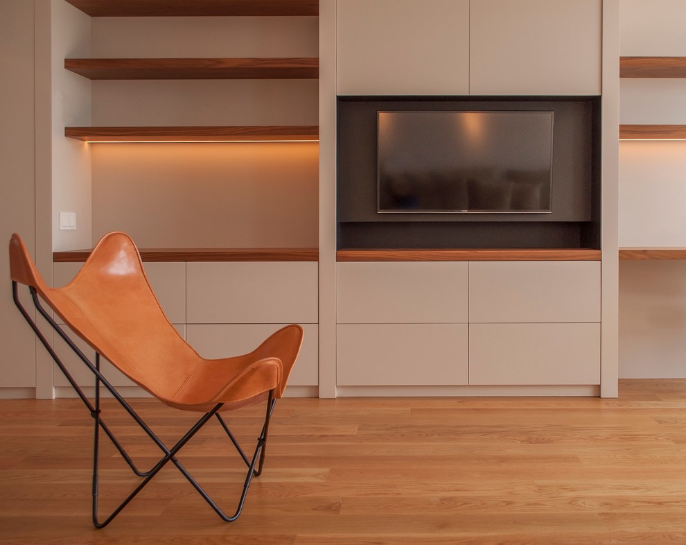 Ejemplo de salón para visitas abierto moderno de tamaño medio sin chimenea con suelo de madera en tonos medios, televisor colgado en la pared y paredes beige