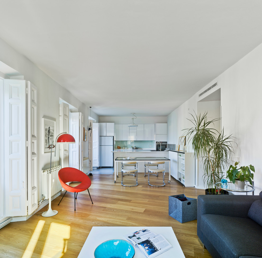 Imagen de salón abierto contemporáneo de tamaño medio con paredes blancas, suelo de madera en tonos medios y suelo marrón
