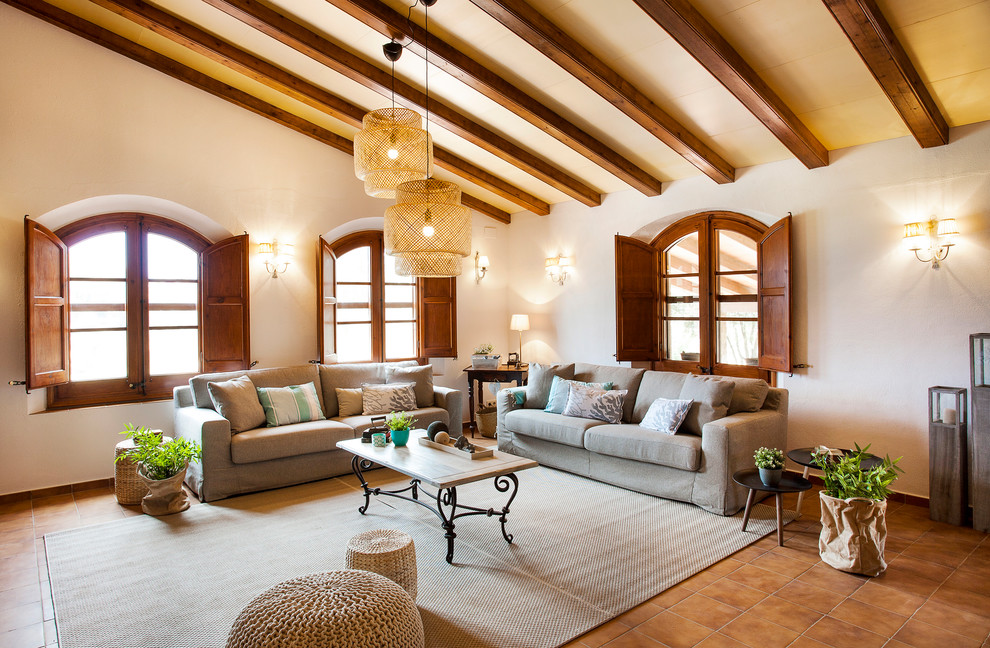 Ejemplo de salón para visitas abierto mediterráneo grande sin chimenea y televisor con paredes beige, suelo marrón y suelo de baldosas de cerámica