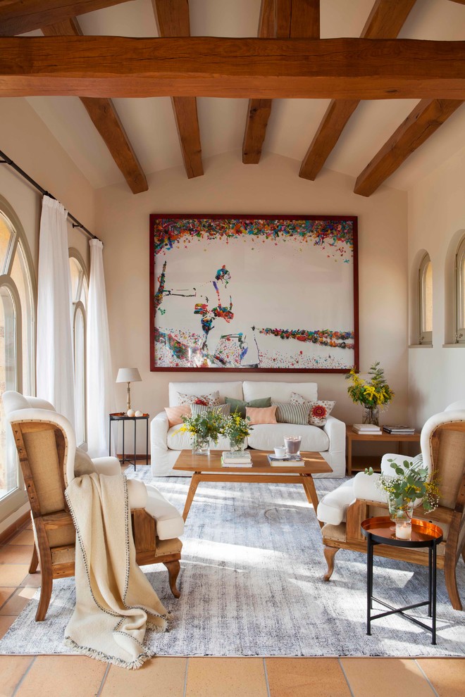 Immagine di un soggiorno mediterraneo chiuso con pareti beige, pavimento in terracotta e nessuna TV