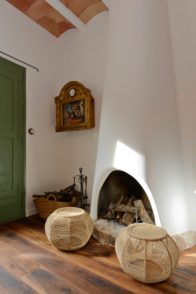 Esempio di un soggiorno mediterraneo di medie dimensioni e chiuso con pareti bianche, pavimento in legno massello medio, TV autoportante e pavimento marrone